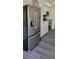 Stainless steel refrigerator in kitchen with white cabinets at 1153 Tamarac Dr, Holiday, FL 34690