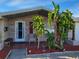 Home's exterior features a covered patio and landscaping at 1153 Tamarac Dr, Holiday, FL 34690