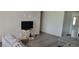 Living room with grey flooring, neutral walls, and a TV at 1153 Tamarac Dr, Holiday, FL 34690