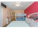 Bedroom with double bed, bunk beds, and red accent wall at 105 Island Way # 121, Clearwater Beach, FL 33767