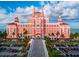 Pink hotel exterior with palm trees and bridge at 1001 Eden Isle Ne Dr # 1, St Petersburg, FL 33704