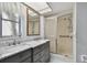 Bathroom featuring double sinks, marble vanity, and a shower with grab bars at 1001 Eden Isle Ne Dr # 1, St Petersburg, FL 33704