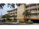 Three-story building with parking and lush landscaping at 692 Bayway Blvd # 202, Clearwater Beach, FL 33767