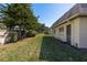 View of a spacious lawn behind a white building with mature trees and a wooden fence at 1442 Normandy Park Dr # 1, Clearwater, FL 33756