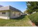 A view of a green lawn and the side of a white building with lush, green landscaping at 1442 Normandy Park Dr # 1, Clearwater, FL 33756