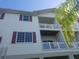 Exterior angle showing balconies, burgundy shutters, and tropical foliage at 3503 10Th W Ln, Palmetto, FL 34221