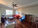Cozy living room featuring a ceiling fan, bright window, comfortable seating, and hardwood floors at 3503 10Th W Ln, Palmetto, FL 34221