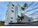 Exterior view of a condo building with balconies, landscaping, and ample parking at 1868 Shore S Dr # 410, South Pasadena, FL 33707