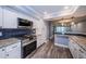 Modern kitchen features granite countertops, stainless appliances, and blue subway tile backsplash at 1868 Shore S Dr # 410, South Pasadena, FL 33707
