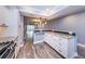 Open-concept kitchen featuring white cabinets, granite countertops, stainless appliances, and wood-look floors at 1868 Shore S Dr # 410, South Pasadena, FL 33707