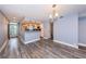 Open-concept living area with wood-look flooring, blue accent wall, and a view into the stainless steel kitchen at 1868 Shore S Dr # 410, South Pasadena, FL 33707