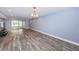 Open-concept living room featuring beautiful flooring, light-blue colored walls, and a modern chandelier at 1868 Shore S Dr # 410, South Pasadena, FL 33707