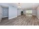Open floor plan with wood-look flooring, blue accent walls, and access to a screened outdoor area at 1868 Shore S Dr # 410, South Pasadena, FL 33707