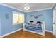 Cozy blue bedroom featuring a daybed with nautical accents, light hardwood floors, and a ceiling fan at 20204 Gulf Blvd # 9, Indian Shores, FL 33785