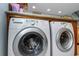 A side-by-side washer and dryer set are built into a wood cabinet with counterspace above it at 20204 Gulf Blvd # 9, Indian Shores, FL 33785