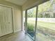 View of grassy backyard through sliding glass doors at 1701 Pinehurst Rd # 26E, Dunedin, FL 34698