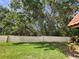 Backyard view of a wall and lush trees beyond at 1701 Pinehurst Rd # 26E, Dunedin, FL 34698