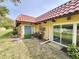 Back exterior view of building showing landscaping and tile roof at 1701 Pinehurst Rd # 26E, Dunedin, FL 34698