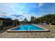 Relaxing community pool with plenty of lounge chairs and a beautiful blue sky at 1701 Pinehurst Rd # 26E, Dunedin, FL 34698