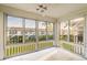 Bright sunroom with ceiling fan and views of the manicured lawn and nearby building at 10350 Imperial Point W Dr # 15, Largo, FL 33774