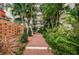 Brick pathway and lush landscaping create a serene courtyard at 2699 Seville Blvd # 105, Clearwater, FL 33764