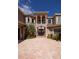 Elegant home featuring a covered entryway with columns, lush landscaping, and a brick paved driveway at 898 Skye Ln, Palm Harbor, FL 34683