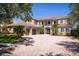 Elegant two-story home featuring a brick driveway, meticulously landscaped yard, and a neutral-toned exterior at 898 Skye Ln, Palm Harbor, FL 34683