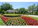 Gated community entrance with lush landscaping and flowering plants at 898 Skye Ln, Palm Harbor, FL 34683