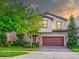 Two story house with brown garage door and landscaping at 12874 Burns Dr, Odessa, FL 33556