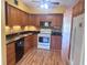 Traditional kitchen featuring wood cabinets, black countertops, and appliances, offering a warm, inviting space at 2256 Philippine Dr # 46, Clearwater, FL 33763