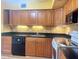 Kitchen features wood cabinets, black appliances, granite countertops, and tile backsplash at 2256 Philippine Dr # 46, Clearwater, FL 33763