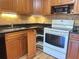 Kitchen featuring wooden cabinets, black countertops, and modern appliances at 2256 Philippine Dr # 46, Clearwater, FL 33763