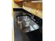 Close-up of stainless steel sink with chrome faucet and black countertop at 2256 Philippine Dr # 46, Clearwater, FL 33763
