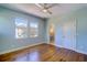Bedroom with hardwood floors, ceiling fan, two windows, and a door opening to a bathroom with a vanity at 6627 Bayou Grande Ne Blvd, St Petersburg, FL 33702