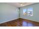 Bedroom features hardwood floors, a ceiling fan, and two windows allowing for natural light to fill the room at 6627 Bayou Grande Ne Blvd, St Petersburg, FL 33702