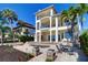 Exterior of a three-story home with balconies, a pool, a spiral staircase, and lush landscaping at 6627 Bayou Grande Ne Blvd, St Petersburg, FL 33702