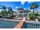 Multi-story waterfront home featuring balconies, a pool, lush landscaping, and private dock at 6627 Bayou Grande Ne Blvd, St Petersburg, FL 33702