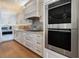 Well-equipped kitchen with stainless steel appliances, custom cabinetry, a mosaic backsplash, and hardwood floors at 6627 Bayou Grande Ne Blvd, St Petersburg, FL 33702