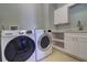 Well-equipped laundry room with front-load washer and dryer, storage cabinets, and a sink for added convenience at 6627 Bayou Grande Ne Blvd, St Petersburg, FL 33702