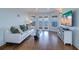 Bright living room with a white sofa, a glass coffee table, and French doors with a water view at 6627 Bayou Grande Ne Blvd, St Petersburg, FL 33702