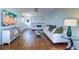 Open-concept living room with white sofas, a glass coffee table, and a flat-screen TV at 6627 Bayou Grande Ne Blvd, St Petersburg, FL 33702