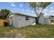 View of the backyard with mature landscaping and a neutral painted exterior at 2305 N Tampania Ave, Tampa, FL 33607
