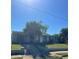 Inviting single-story home featuring a well-manicured lawn, mature trees, and updated facade at 2305 N Tampania Ave, Tampa, FL 33607