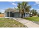 Charming single-story home with a covered carport, mature landscaping, and a concrete driveway leading to the entrance at 2305 N Tampania Ave, Tampa, FL 33607