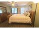 Well-lit bedroom featuring a comfortable bed, wooden furniture, and a ceiling fan at 103 Cypress Pond Rd # 103, Palm Harbor, FL 34683