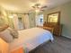 Bedroom with wood floors, a ceiling fan, sliding barn door, and access to ensuite bathroom at 103 Cypress Pond Rd # 103, Palm Harbor, FL 34683