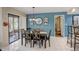 Stylish dining area with blue walls, tile floors, modern lighting, and access to the lanai at 103 Cypress Pond Rd # 103, Palm Harbor, FL 34683