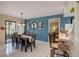 Open dining room features stylish blue accent wall, table and chairs with sliding glass door at 103 Cypress Pond Rd # 103, Palm Harbor, FL 34683