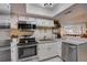 Functional kitchen with white cabinets, stainless steel appliances, and bar seating area at 103 Cypress Pond Rd # 103, Palm Harbor, FL 34683