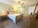 Cozy main bedroom boasts wood floors, a ceiling fan, and a barn door to the bathroom at 103 Cypress Pond Rd # 103, Palm Harbor, FL 34683